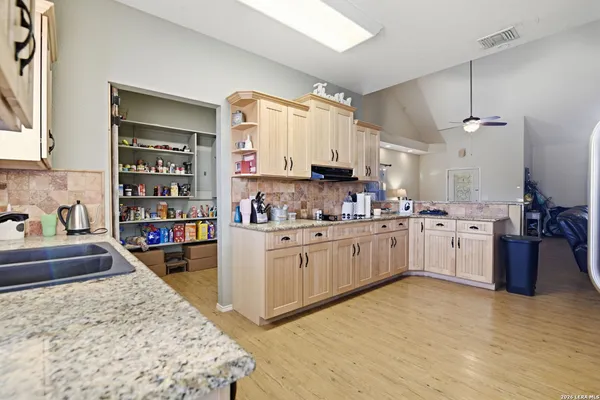 a kitchen with stainless steel appliances kitchen island granite countertop a stove sink and cabinets