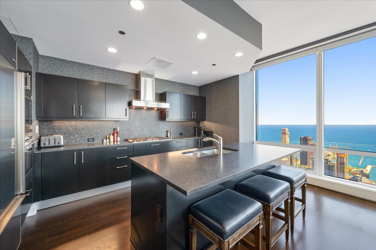 401 North Wabash Avenue, Unit 73F Chicago, IL 60611 - Photo 4 of 40 a kitchen with a table chairs microwave and cabinets