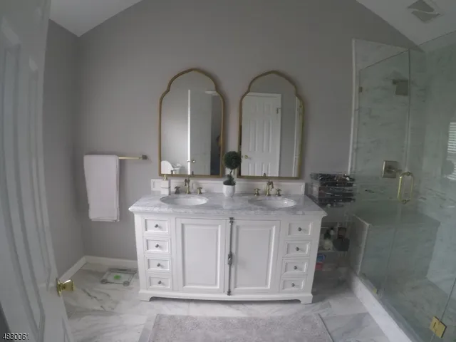 a bathroom with a double vanity sink a toilet and a mirror