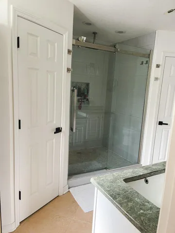 a bathroom with a granite countertop sink mirror and shower