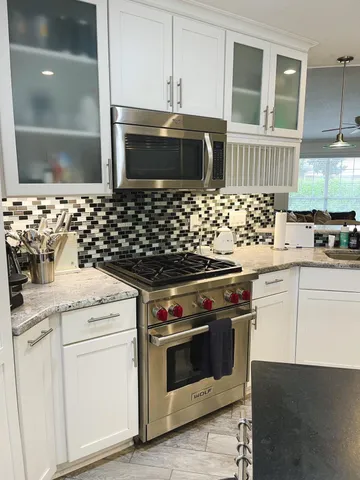 a kitchen with stainless steel appliances a stove a sink and a microwave