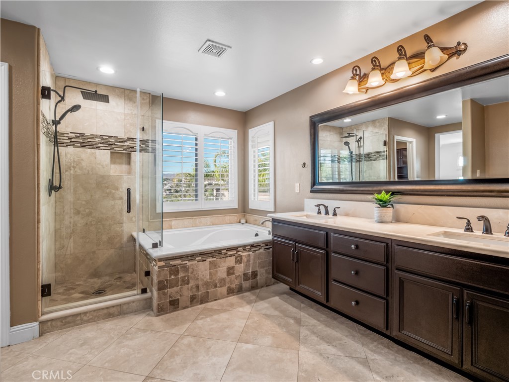 29461 Sequoia Road Canyon Country, CA 91387 - Photo 23 of 51 a spacious bathroom with a double vanity sink a large mirror and a bathtub