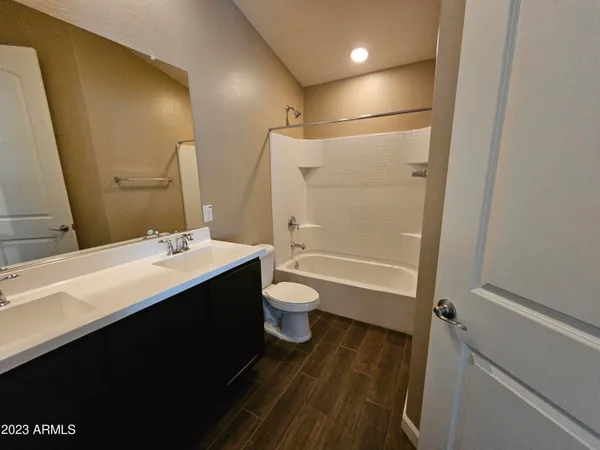 a bathroom with a double vanity sink toilet mirror and shower