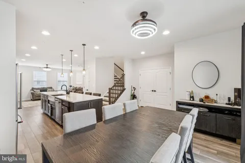 a living room with furniture kitchen view and a wooden floor