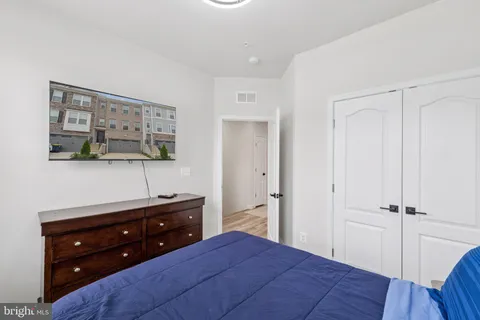 a bedroom with a bed and a closet with mirror