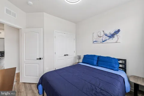 a bedroom with a bed and a painting on the wall