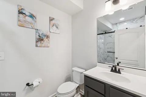 a bathroom with a sink mirror vanity and toilet