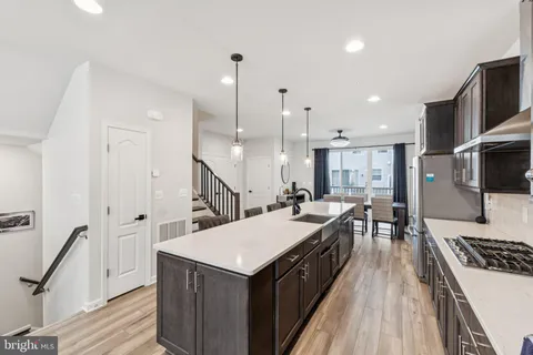 a kitchen with a stove a sink a microwave and wooden floor