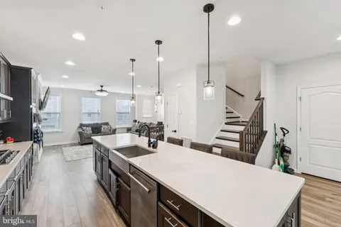 a large kitchen with sink a refrigerator and wooden floor