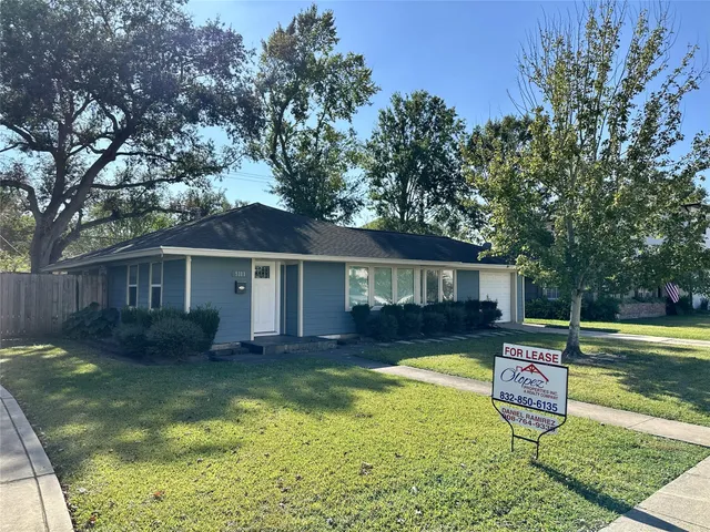 a view of a house with backyard and a tree