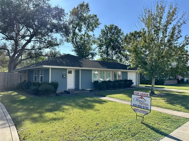 a view of a house with backyard and a tree