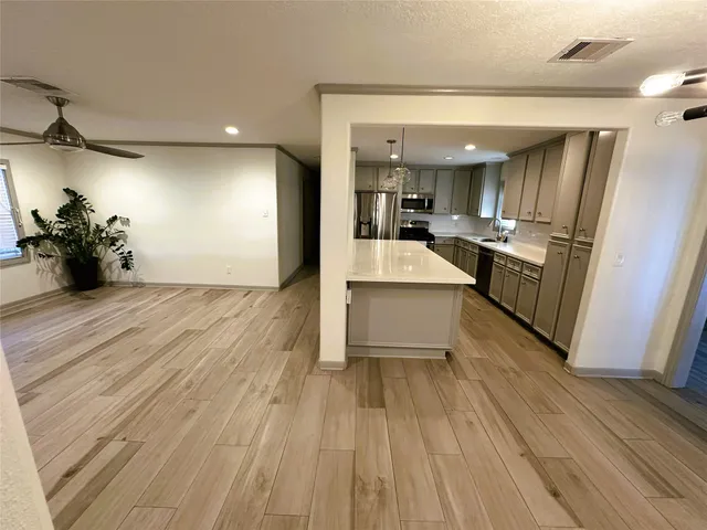 a view of a living room a kitchen and a wooden floor