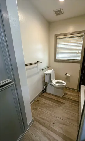 a bathroom with a sink a toilet a window and vanity