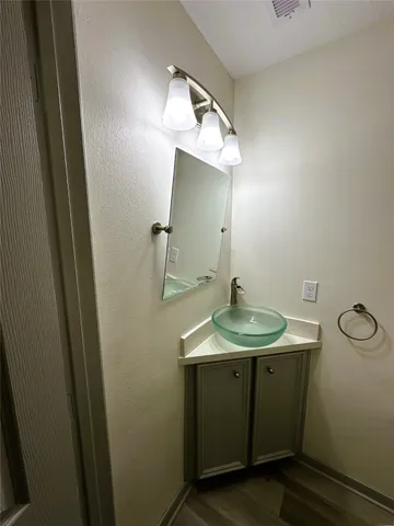 a bathroom with a granite countertop sink a mirror and vanity
