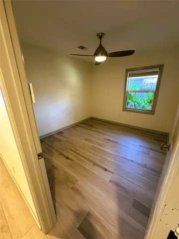 a view of empty room with wooden floor