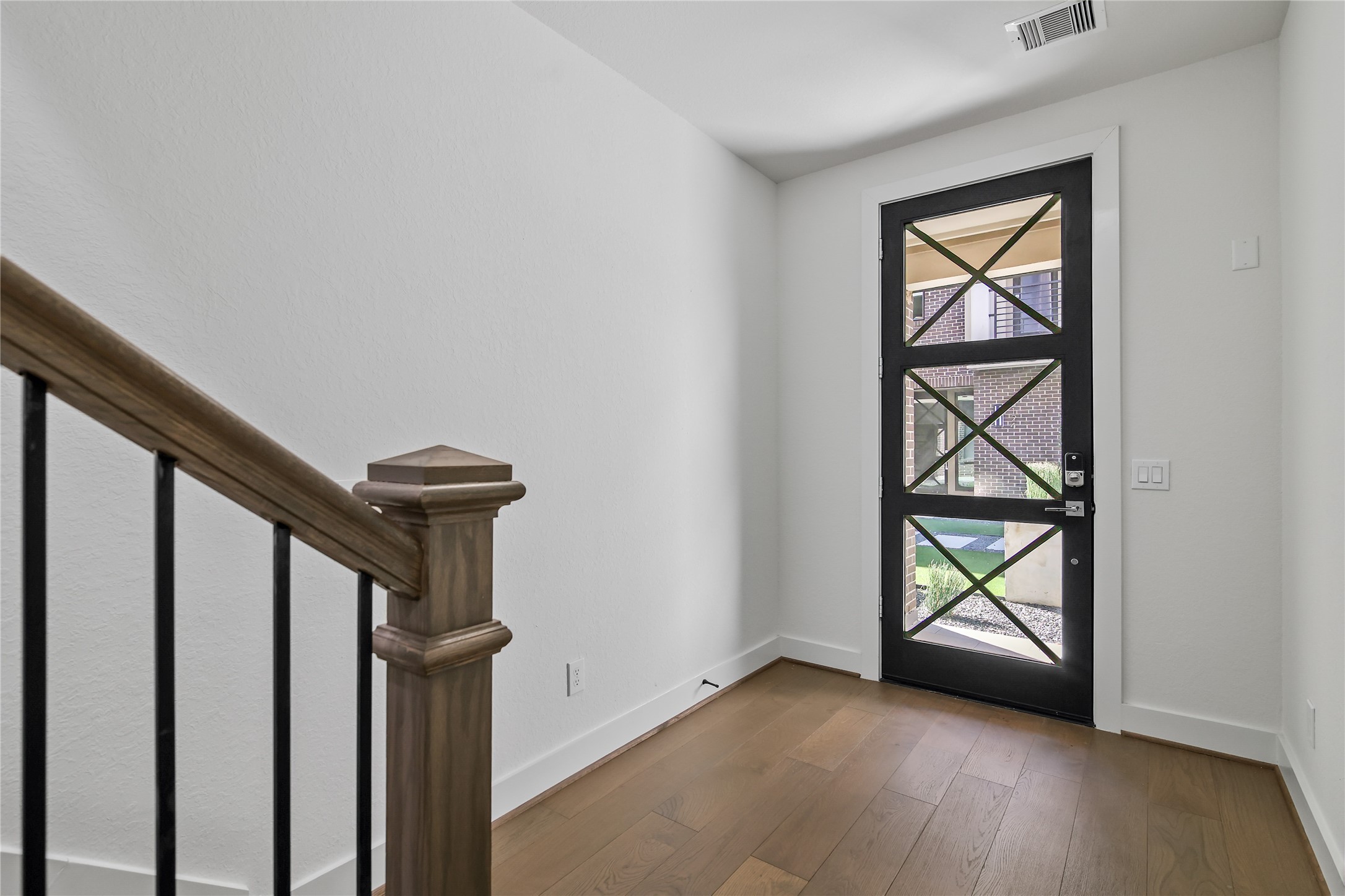 4231 Allen Street Houston, TX 77007 - Photo 10 of 31 Entryway features a stylish, modern door, spacious entry, warm wood flooring and the downstairs bedroom is to the right of this picture.