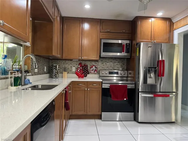 a kitchen with a sink refrigerator and microwave
