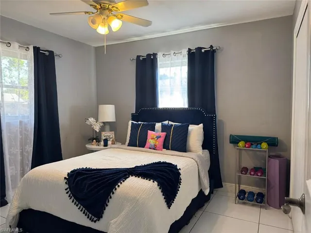 a bedroom with a bed a window and potted plant