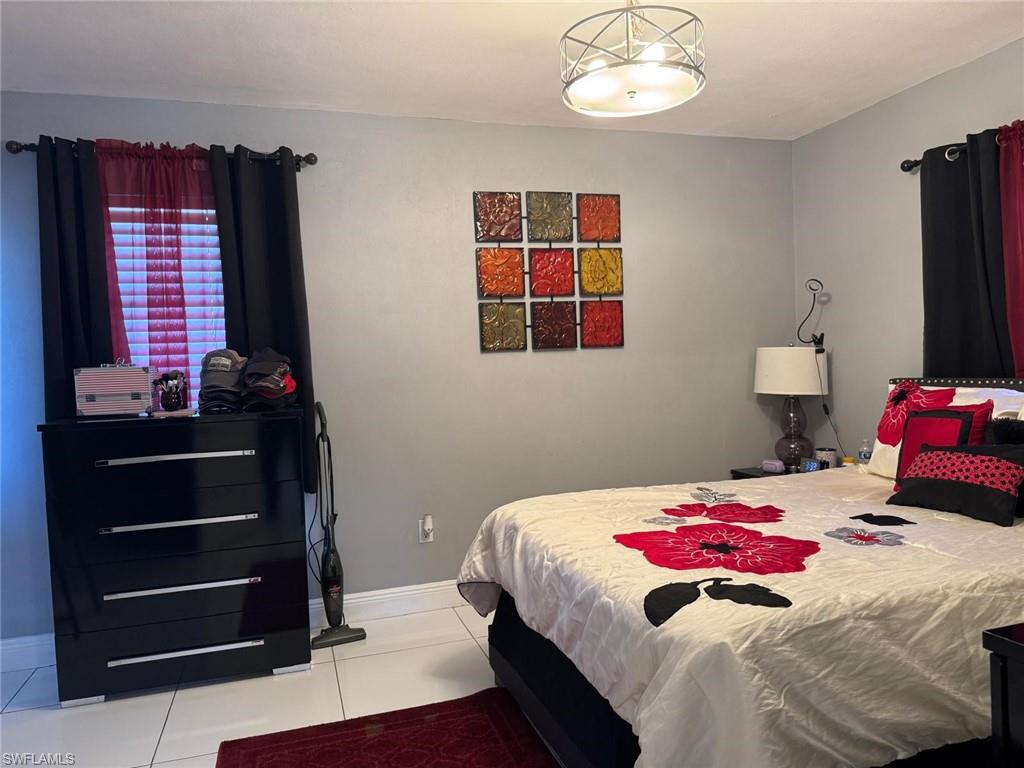 4454 19th Place Southwest Naples, FL 34116 - Photo 19 of 30 a bedroom with a bed and a chandelier