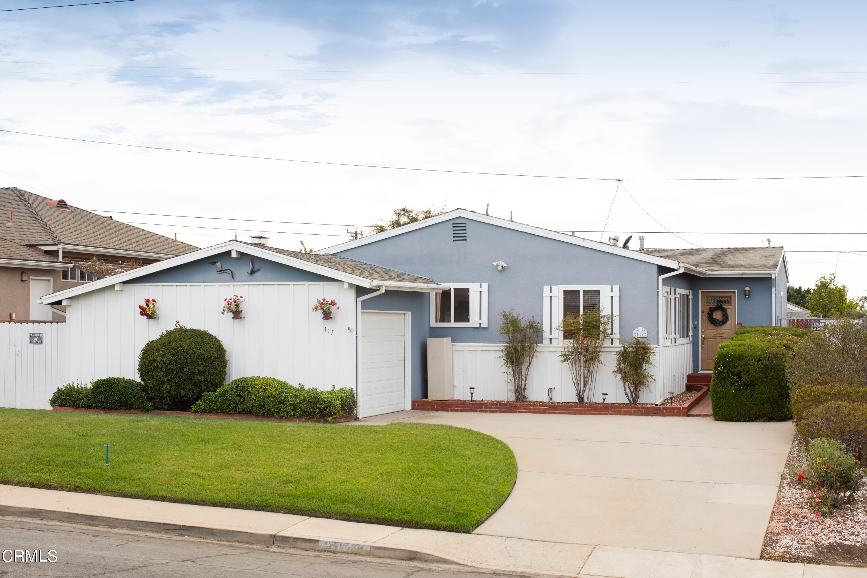 a view of a white house next to a yard