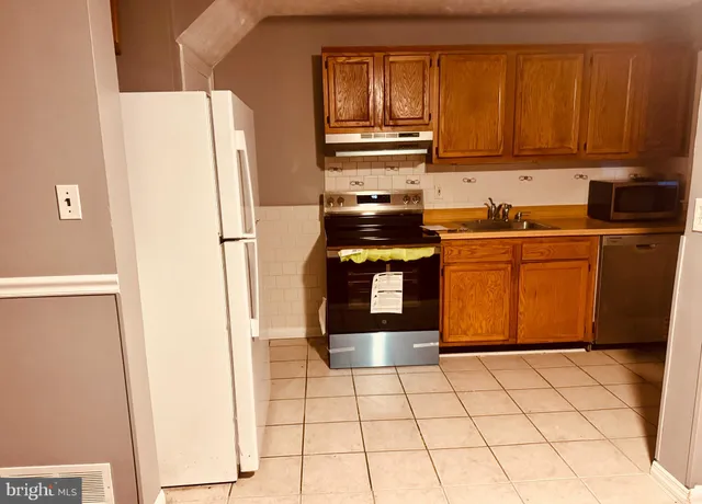 a kitchen with stainless steel appliances granite countertop a refrigerator sink and cabinets