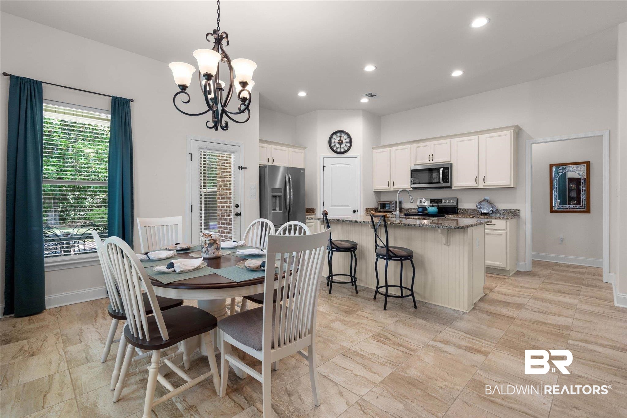 1270 Surrey Loop Foley, AL 36535 - Photo 5 of 27 Kitchen and dining area featuring wood-finish tile flooring, white cabinetry, a kitchen island with seating, stainless steel appliances, and recessed lighting