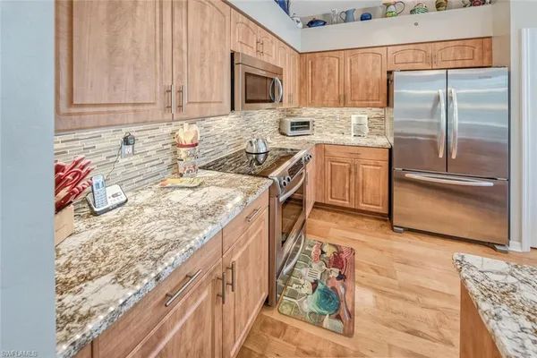 a kitchen with stainless steel appliances granite countertop a stove a sink and a refrigerator