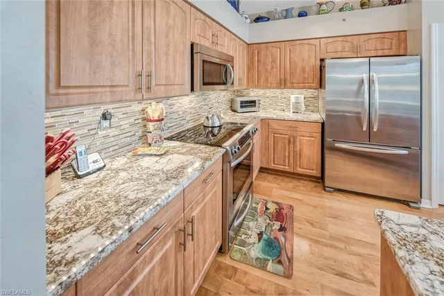 a kitchen with stainless steel appliances granite countertop a stove a sink and a refrigerator