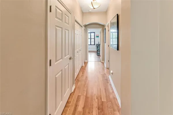 a view of a hallway with wooden floor and staircase