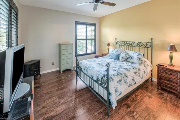 a bedroom with a bed and a flat tv screen on dresser