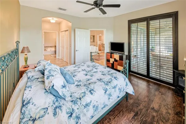 a bedroom with a large bed and a flat tv screen
