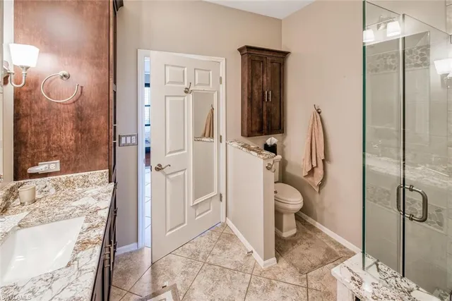 a bathroom with a granite countertop shower and a sink