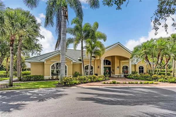 a front view of a house with a yard and potted plants