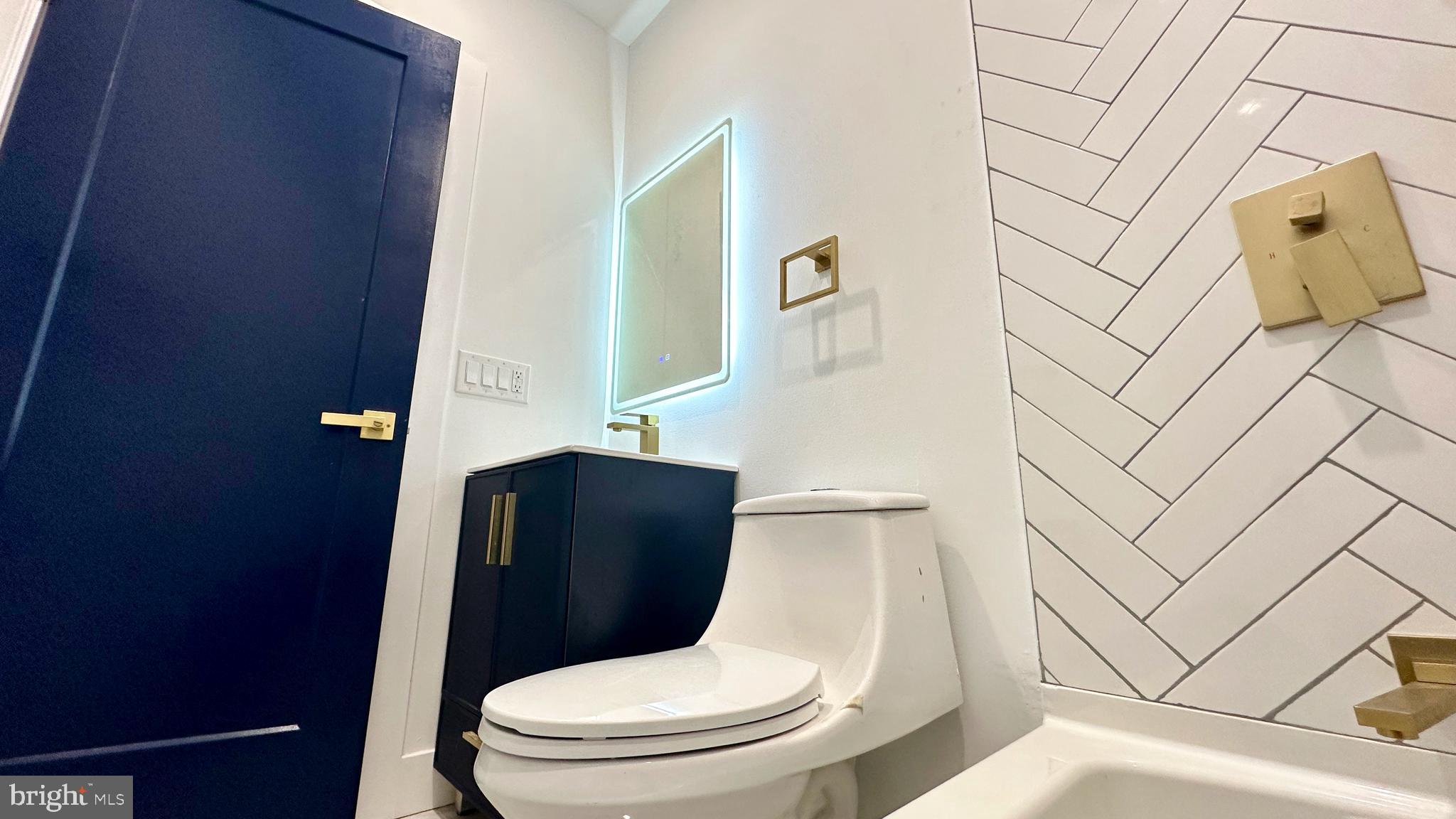 4525 North Gratz Street, Unit A Philadelphia, PA 19140 - Photo 9 of 21 a white toilet sitting next to a bathroom sink and vanity