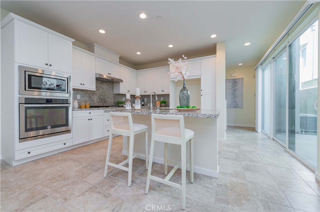 184 Terrapin Irvine, CA 92618 - Photo 12 of 74 a kitchen with stainless steel appliances kitchen island granite countertop a refrigerator and cabinets
