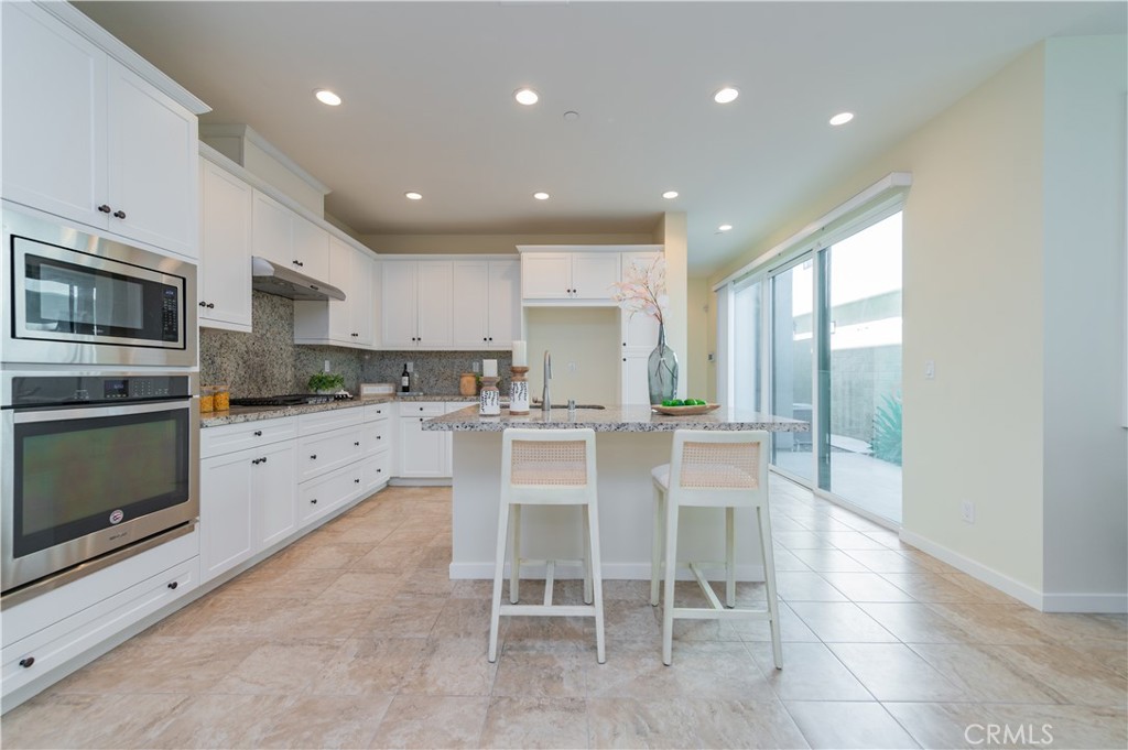184 Terrapin Irvine, CA 92618 - Photo 13 of 74 a kitchen with stainless steel appliances granite countertop a stove top oven a sink dishwasher a refrigerator and white cabinets with wooden floor