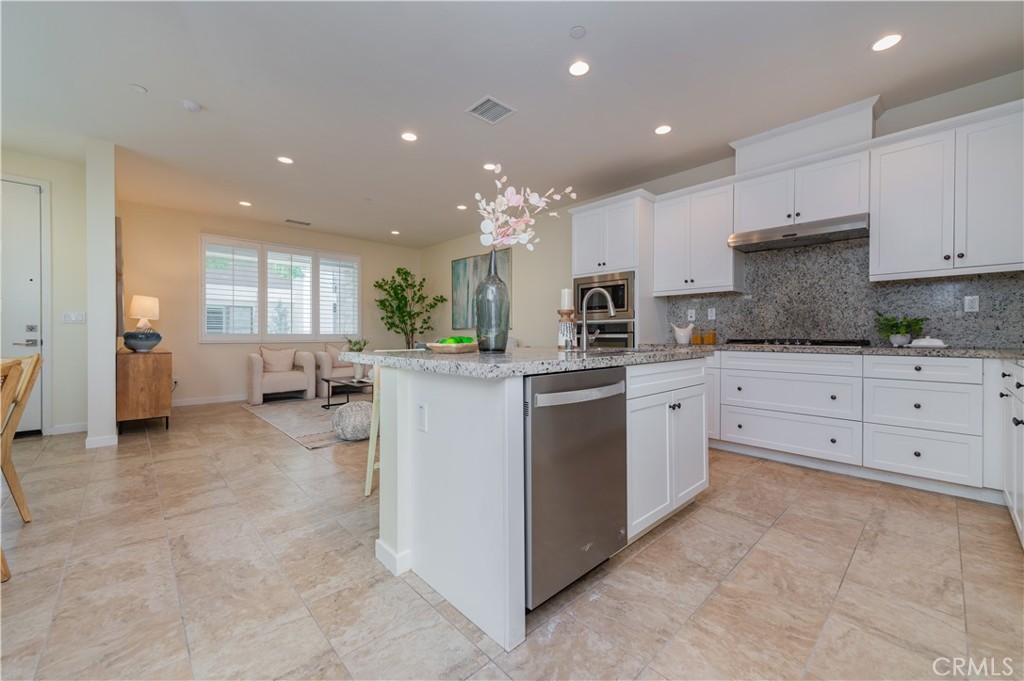 184 Terrapin Irvine, CA 92618 - Photo 16 of 74 a kitchen with kitchen island granite countertop a white stove top oven and cabinets