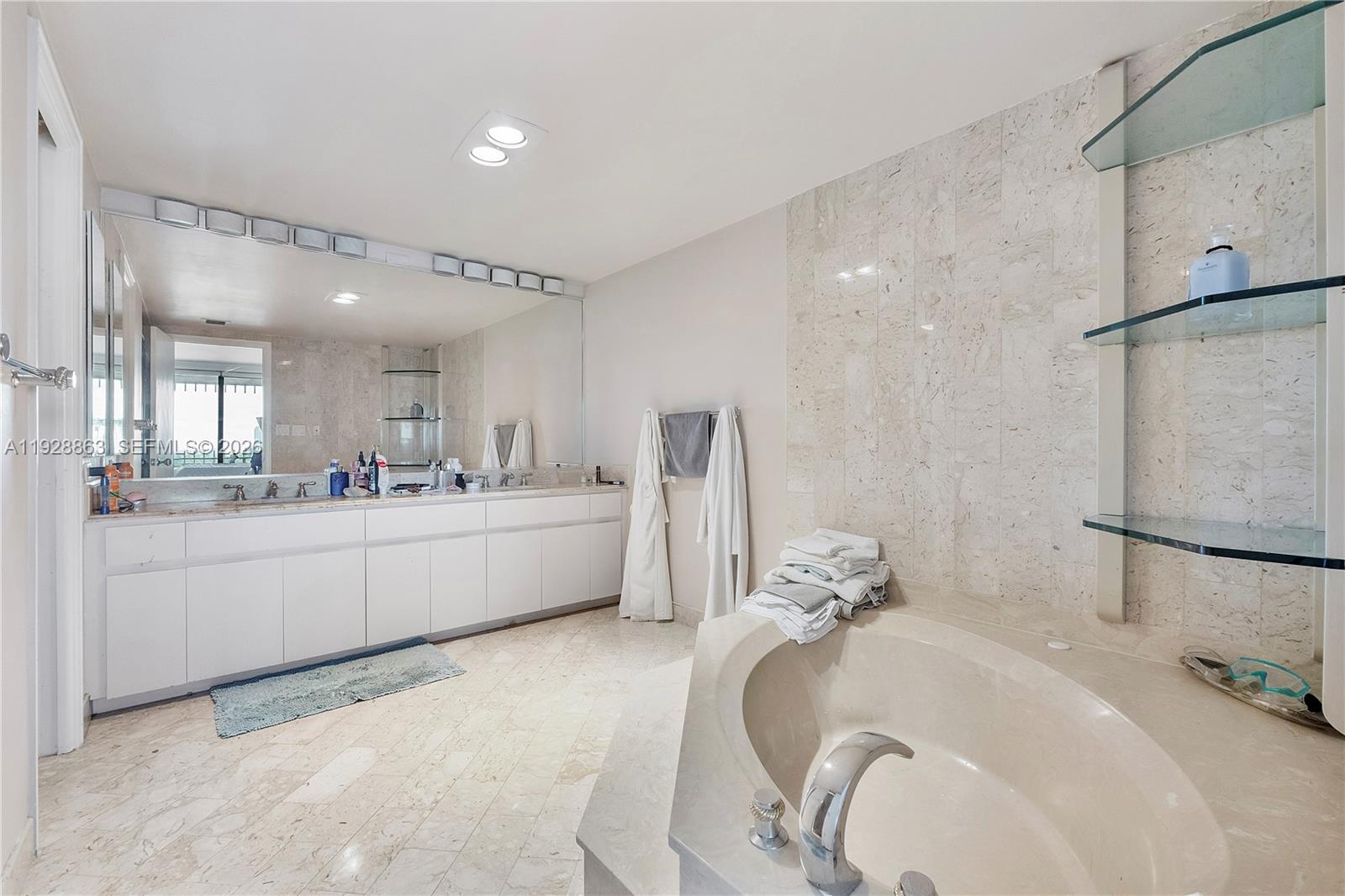 2 Grove Isle Drive, Unit B1110 Miami, FL 33133 - Photo 15 of 29 a bathroom with a tub sink and mirror