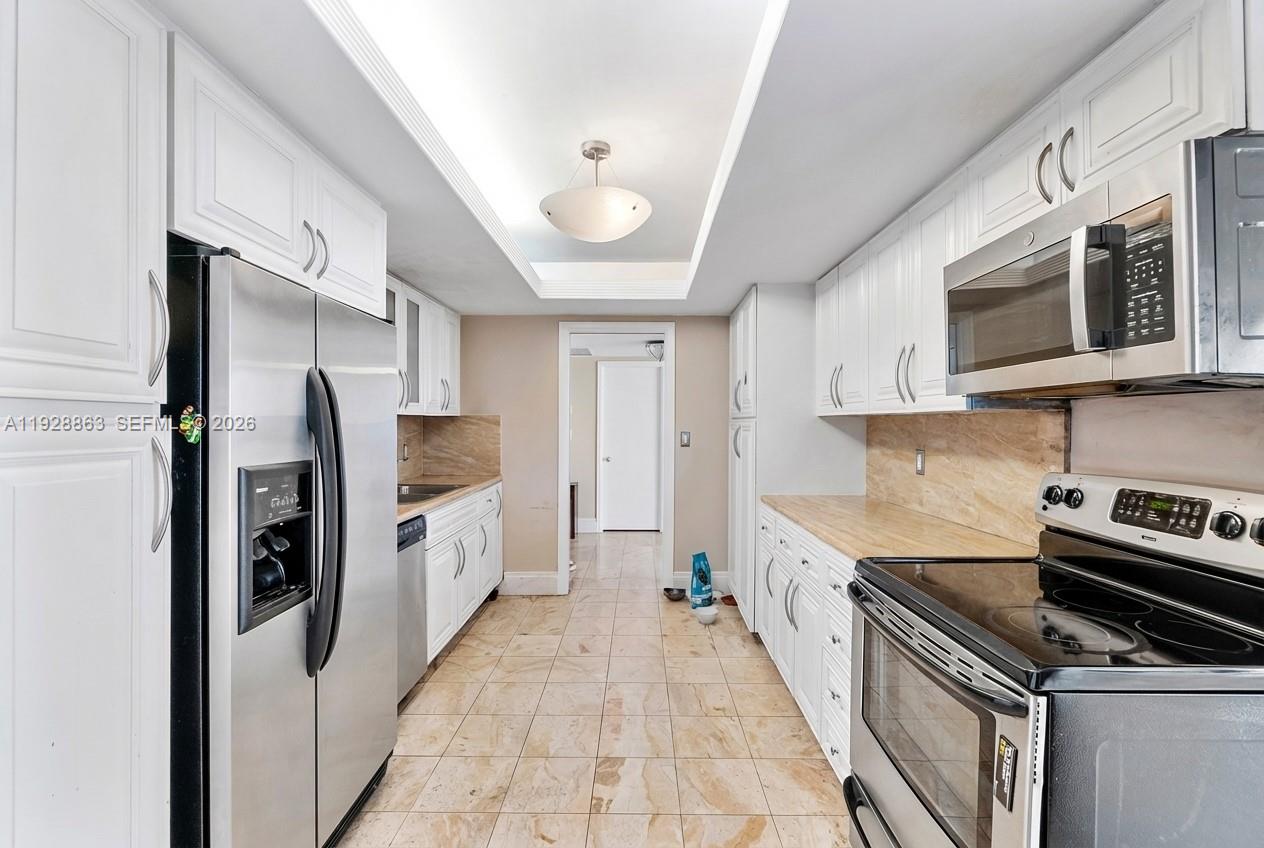 2 Grove Isle Drive, Unit B1110 Miami, FL 33133 - Photo 3 of 29 a kitchen with stainless steel appliances a stove microwave and refrigerator