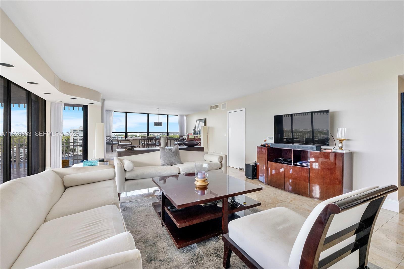 2 Grove Isle Drive, Unit B1110 Miami, FL 33133 - Photo 4 of 29 a living room with furniture a flat screen tv and a dining table with wooden floor