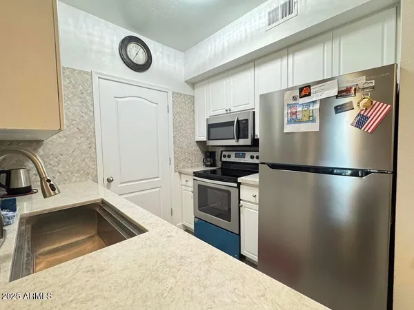 a kitchen with a refrigerator sink and stainless steel appliances