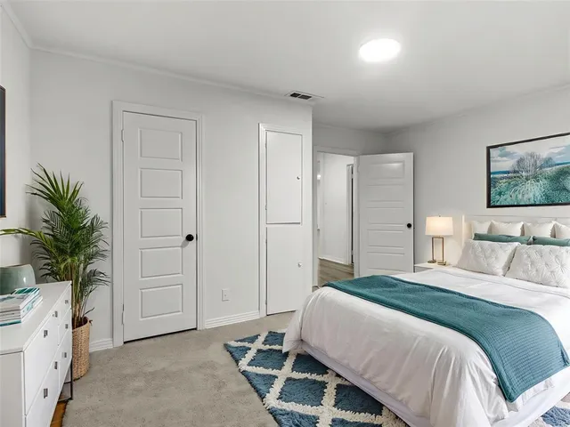 a bedroom with a bed and a potted plant