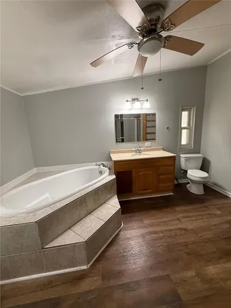 a spacious bedroom with a bed and ceiling fan
