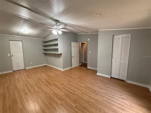 a view of empty room with wooden floor