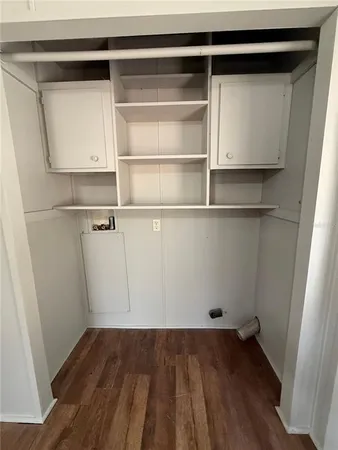 a view of a room with wooden floor and cabinet