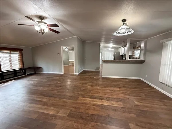 a view of a room with natural light kitchen appliances and a chandelier