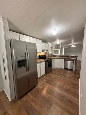 a kitchen with stainless steel appliances granite countertop a refrigerator a stove and a sink
