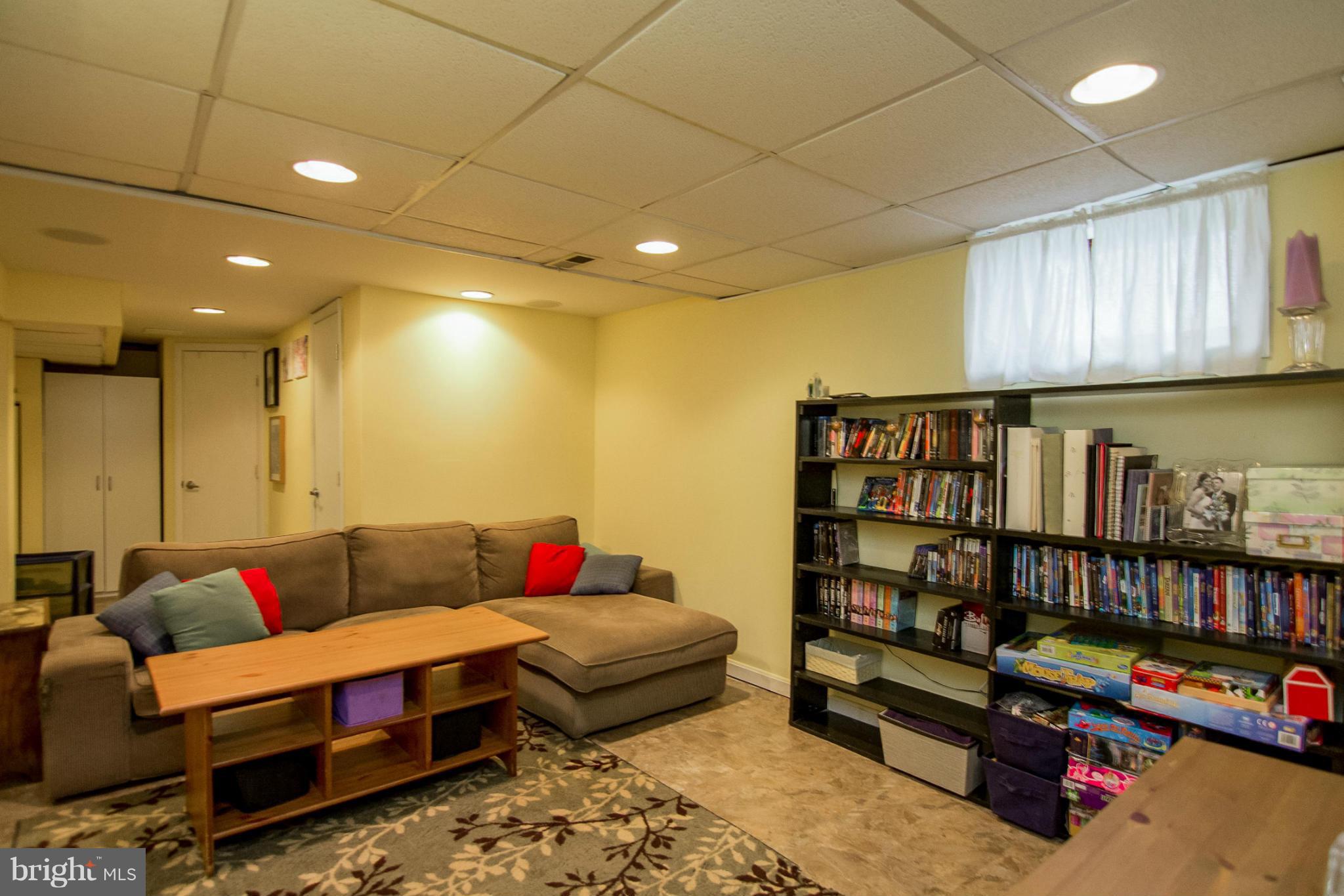 5544 Gayland Road Baltimore, MD 21227 - Photo 17 of 24 a living room with furniture a rug and a book shelf