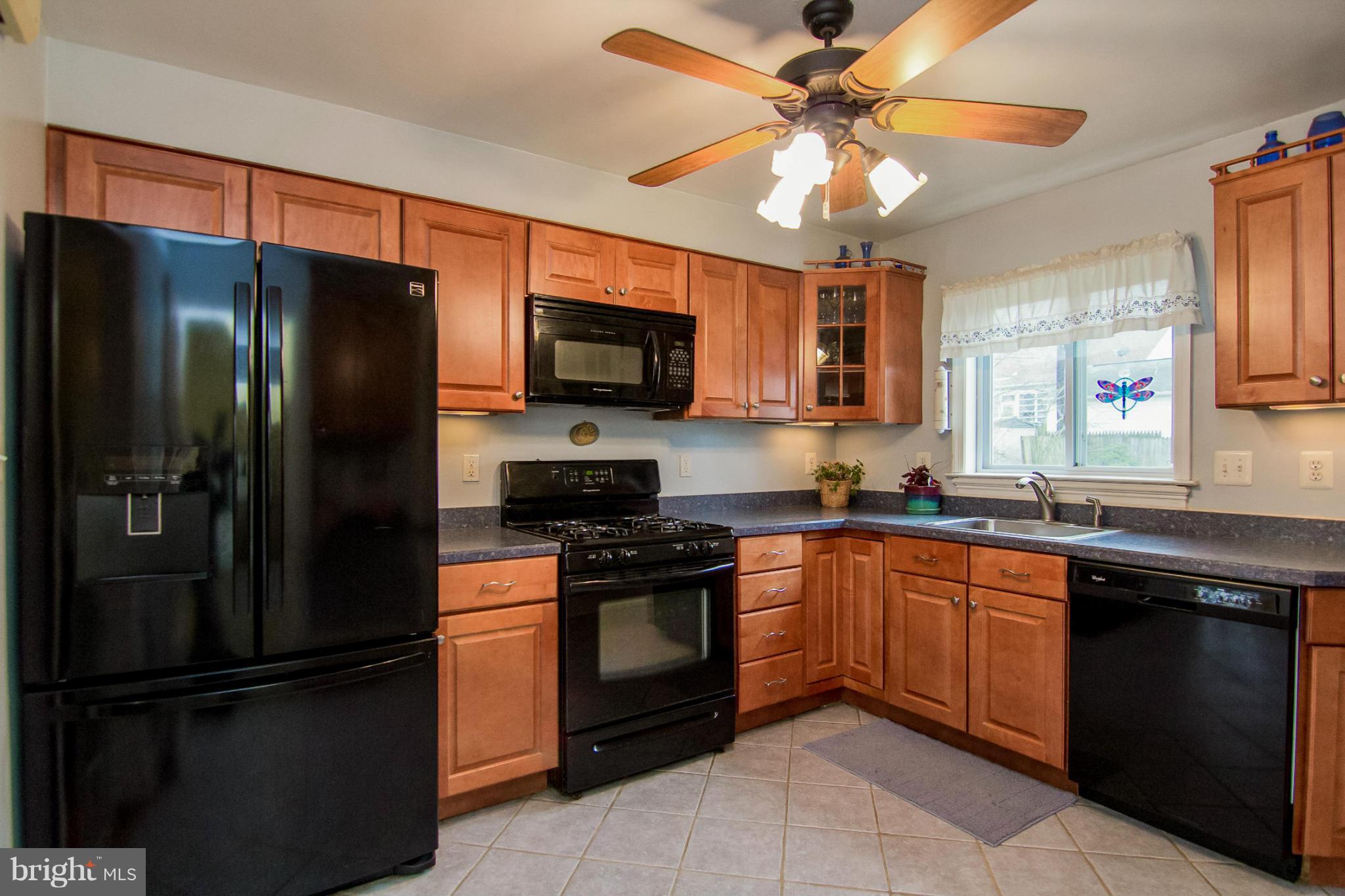 5544 Gayland Road Baltimore, MD 21227 - Photo 4 of 24 a kitchen with stainless steel appliances granite countertop a refrigerator a stove a sink a washer and dishwasher with kitchen island