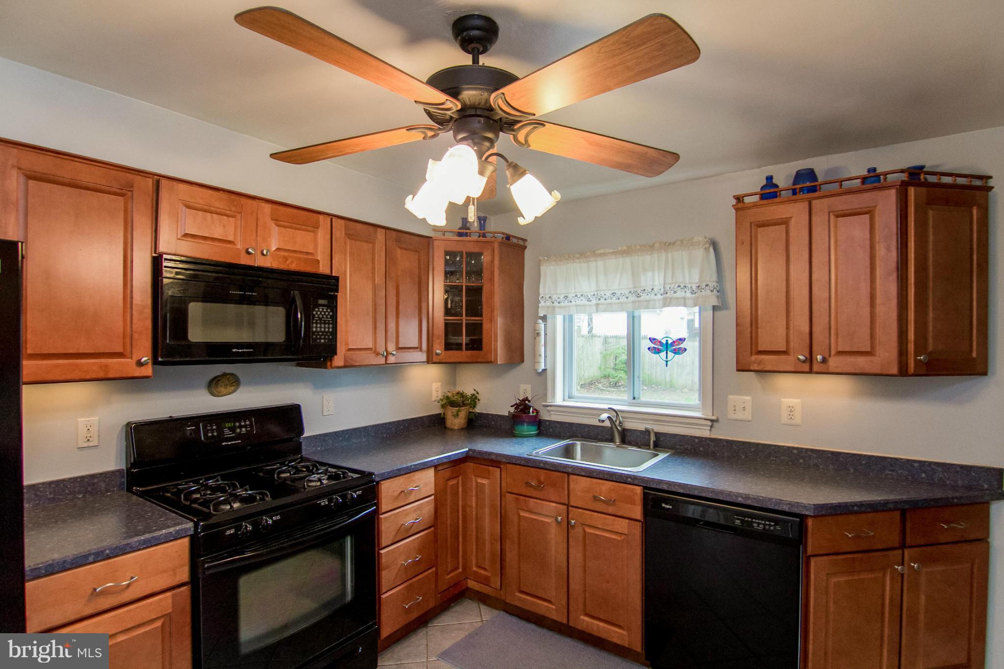 5544 Gayland Road Baltimore, MD 21227 - Photo 7 of 24 a kitchen with stainless steel appliances granite countertop a sink a stove and a microwave